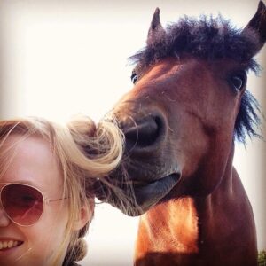 A horse looking at its owner's hair